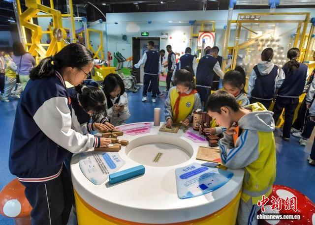 9月18日，新疆乌鲁木齐市，中小学生在新疆科技馆体验鲁班锁、华容道等益智装置。中新社记者 刘新 摄