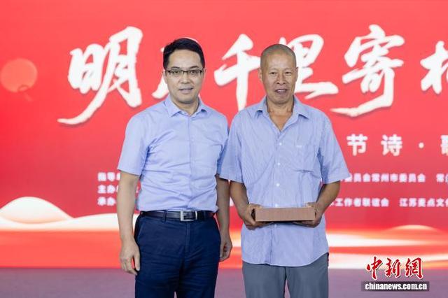 闻全妹老人的儿子(右一)作为家庭代表来到现场，常州市台办主任汤建忠为其送上象征团圆的中秋月饼。张梁 摄