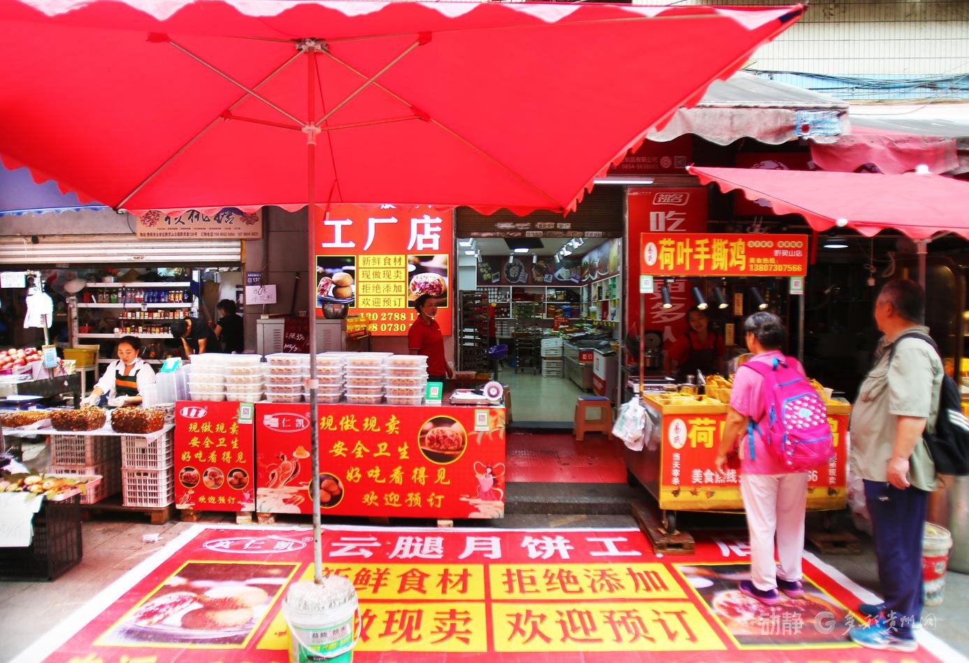 红伞映店铺，标语递温情，是黔灵巷里的鲜活小景