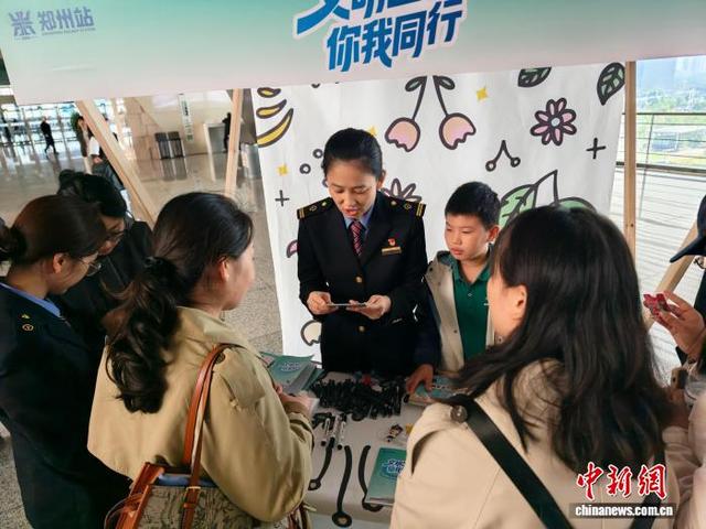图为郑州东站，工作人员为旅客宣讲文明出行常识。郎季龙 摄