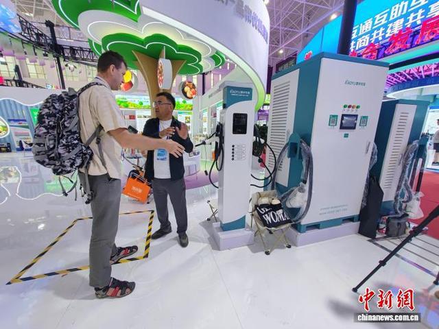 在第十五届新疆喀什·中亚南亚商品交易会上，中国生产的新能源汽车充电设备吸引外媒记者目光。王小军 摄
